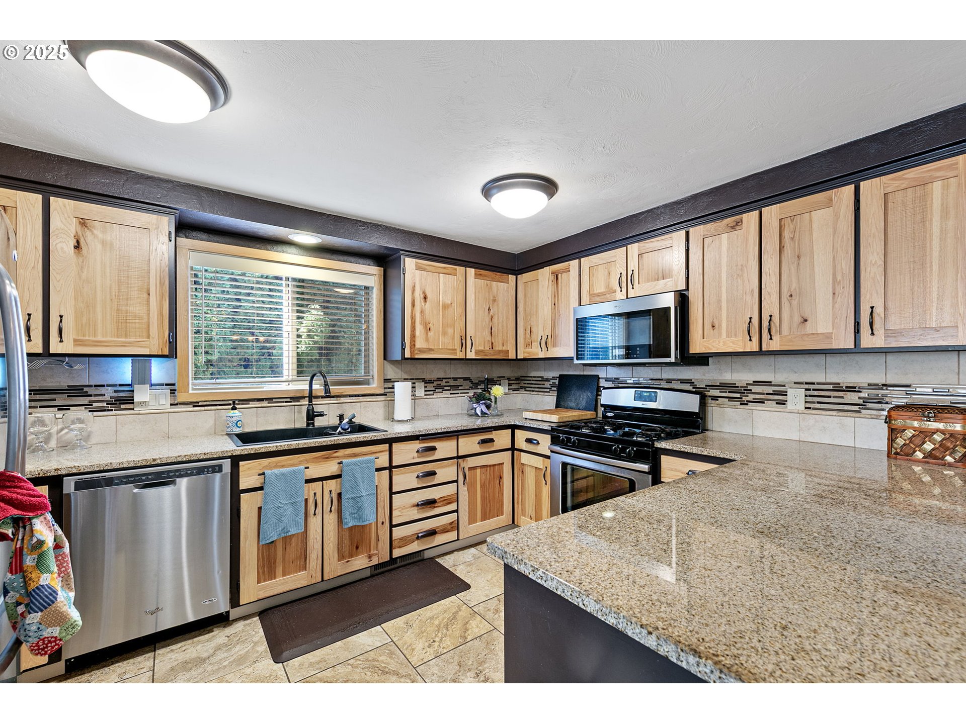 1011 Rose Street Junction City, OR 97448 - Photo 14 of 44 a kitchen with stainless steel appliances granite countertop a stove top oven a sink dishwasher a dining table and chairs