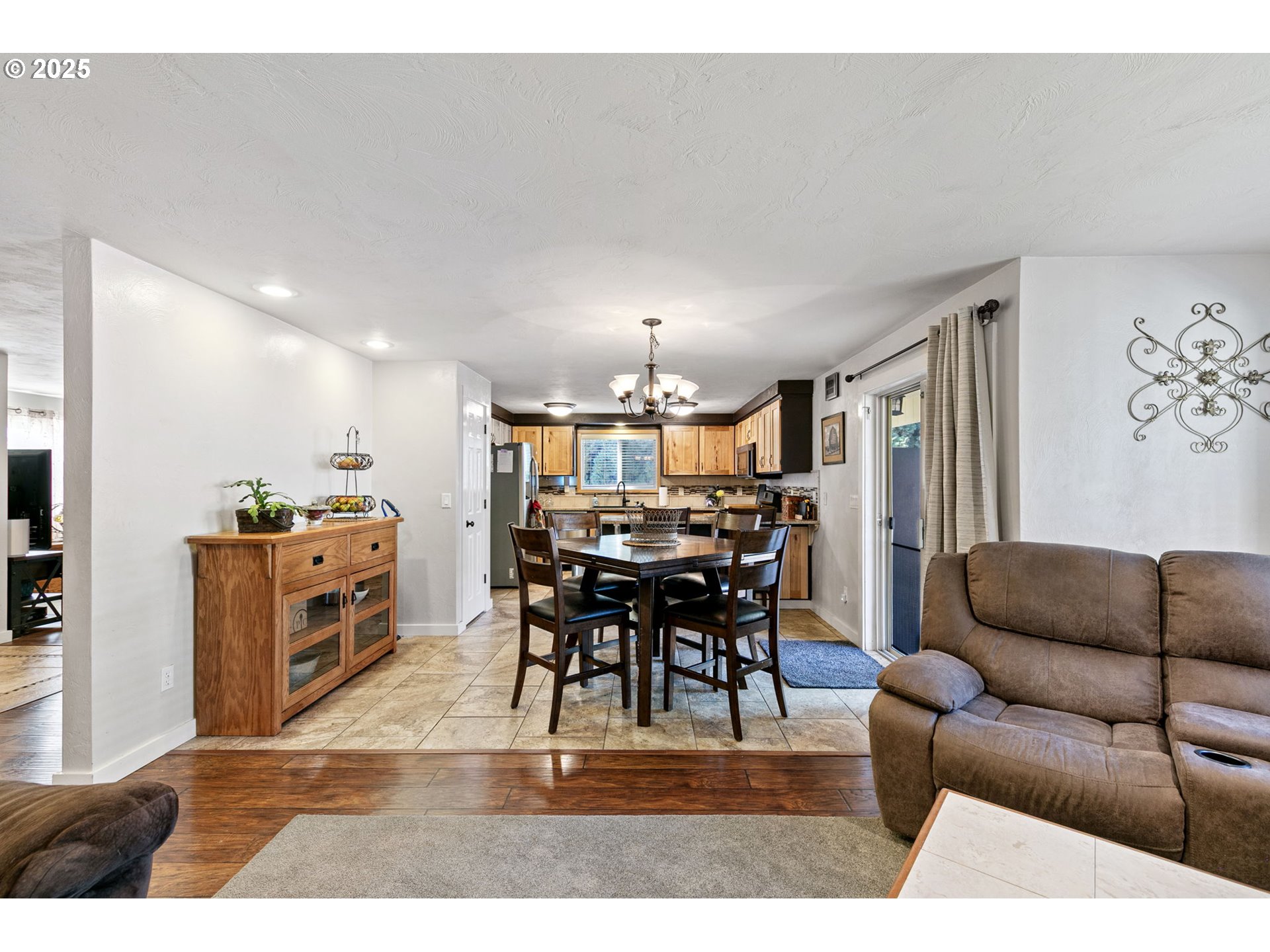 1011 Rose Street Junction City, OR 97448 - Photo 22 of 44 a living room with furniture a dining table and a chandelier