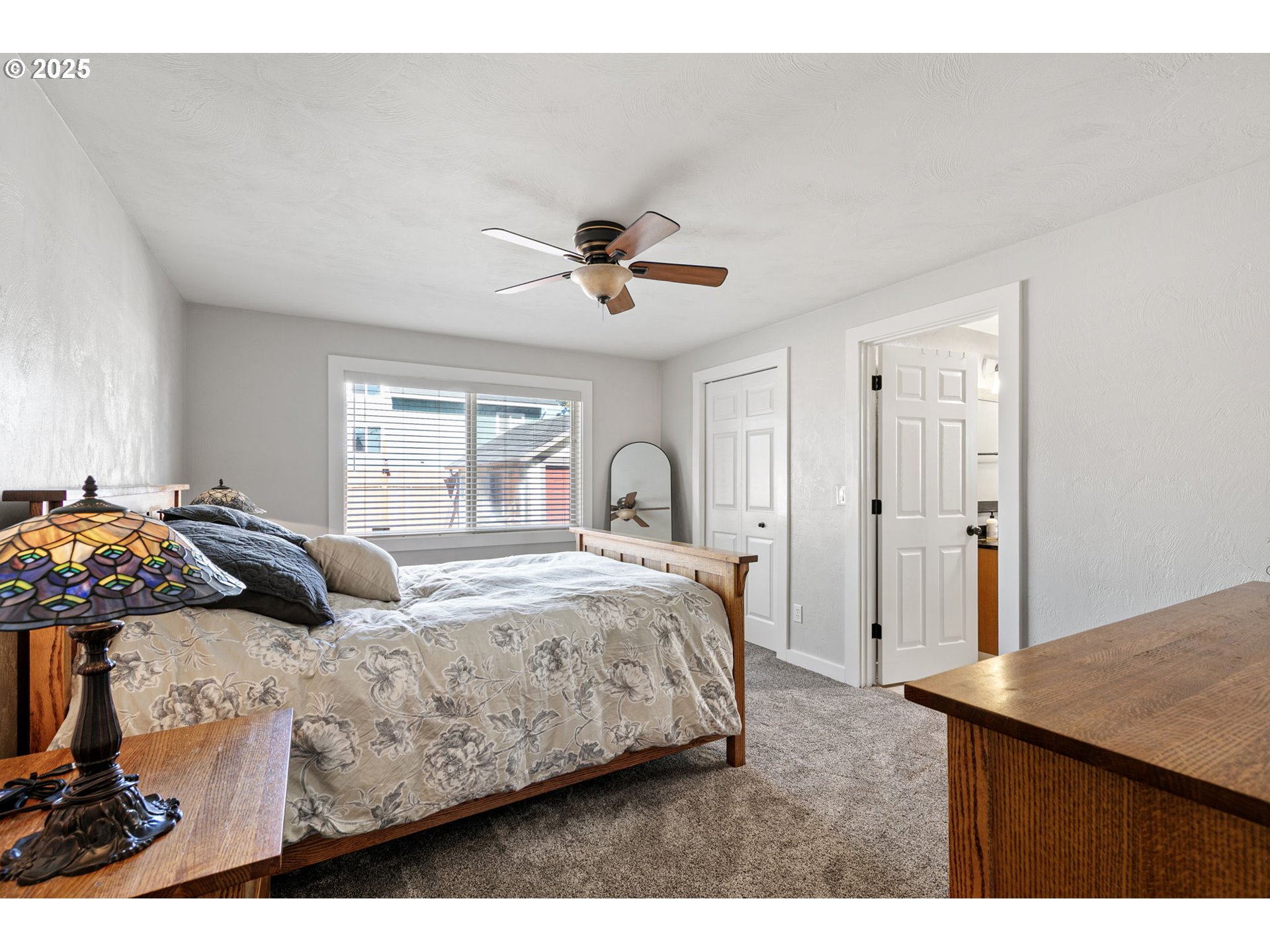 1011 Rose Street Junction City, OR 97448 - Photo 23 of 44 a bedroom with a bed and a ceiling fan