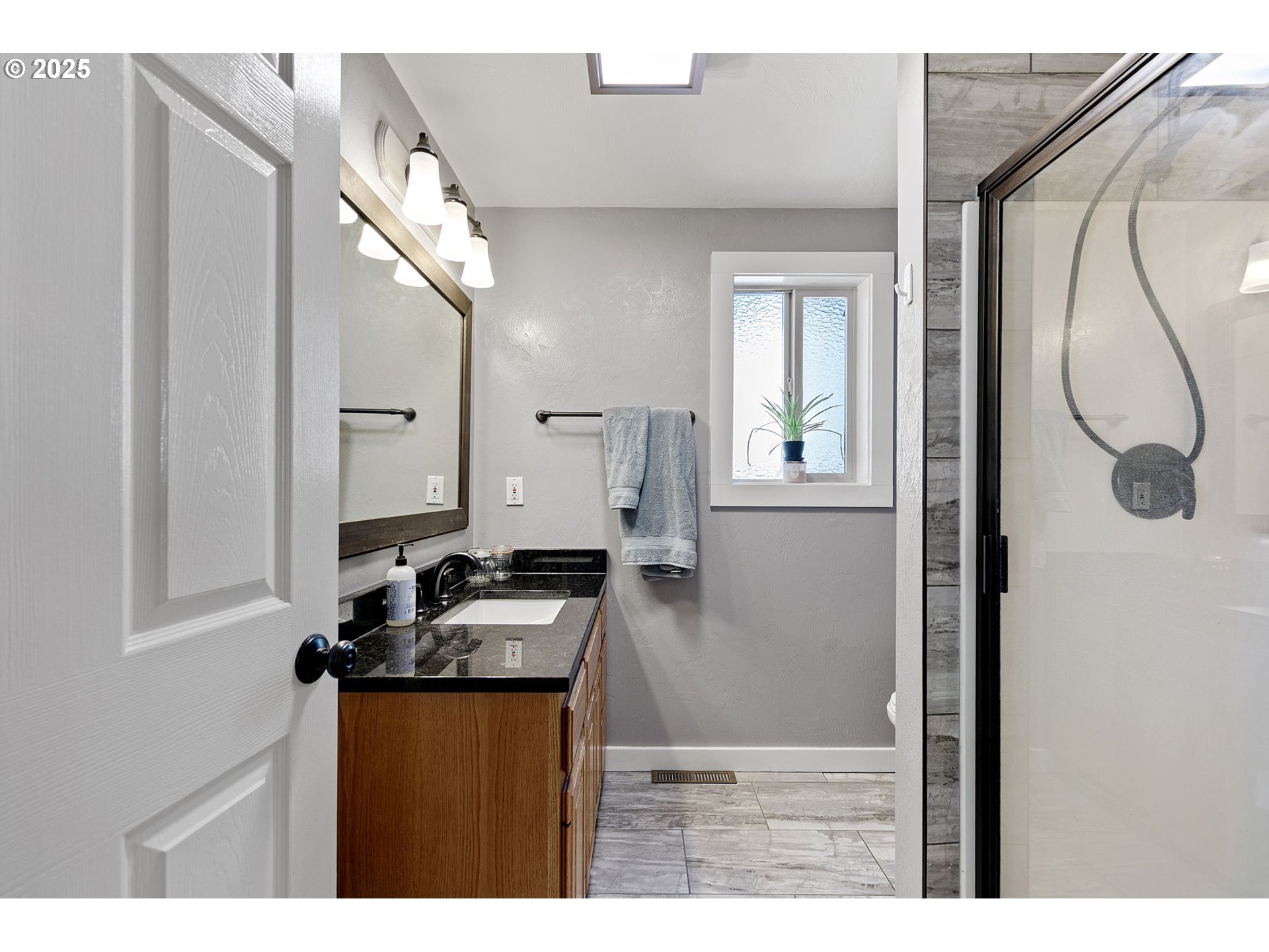 1011 Rose Street Junction City, OR 97448 - Photo 27 of 44 a bathroom with a granite countertop sink a mirror and shower