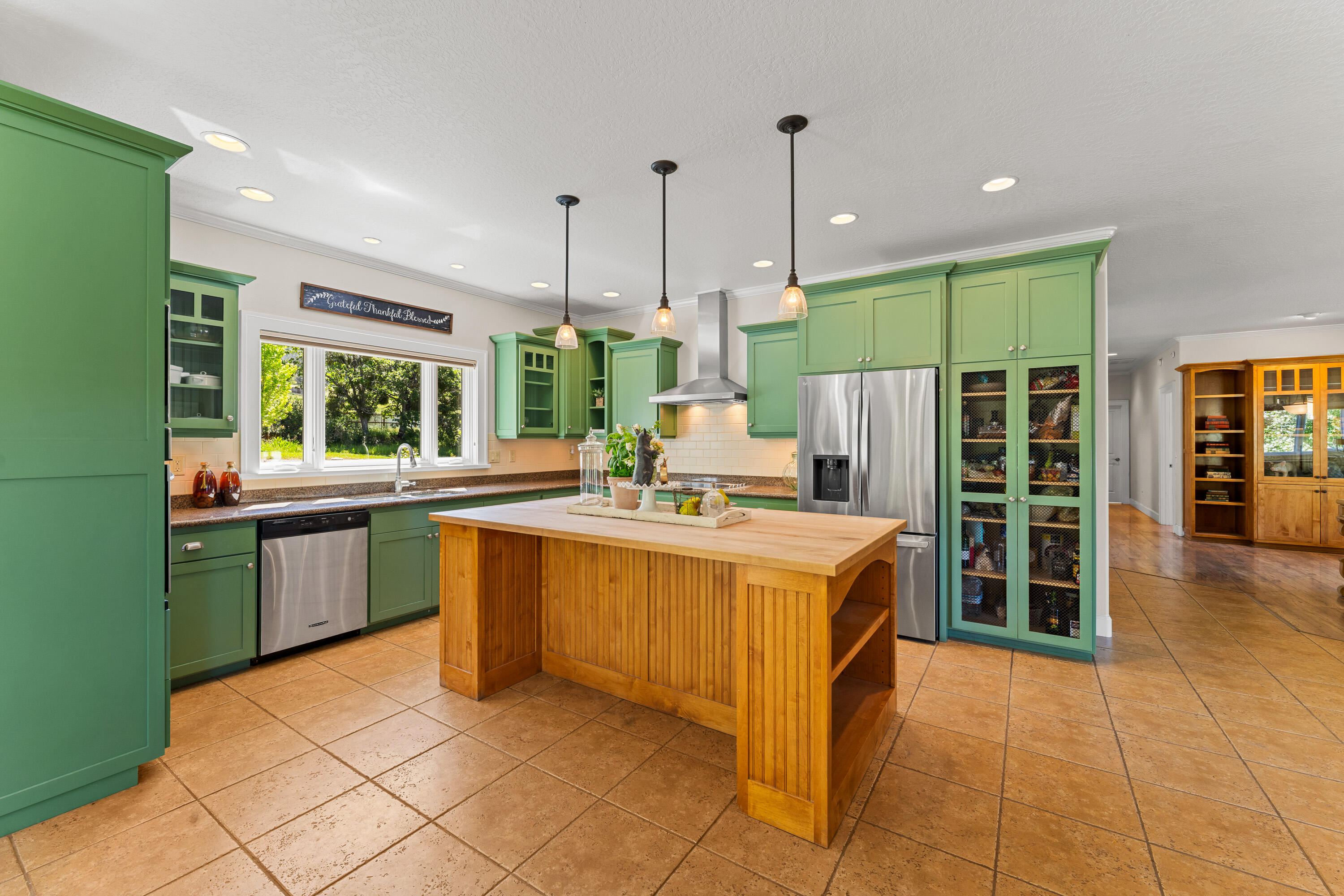 931 Hogan Road Jacksonville, OR 97530 - Photo 54 of 74 a kitchen with kitchen island a large counter top space a sink stainless steel appliances and cabinets