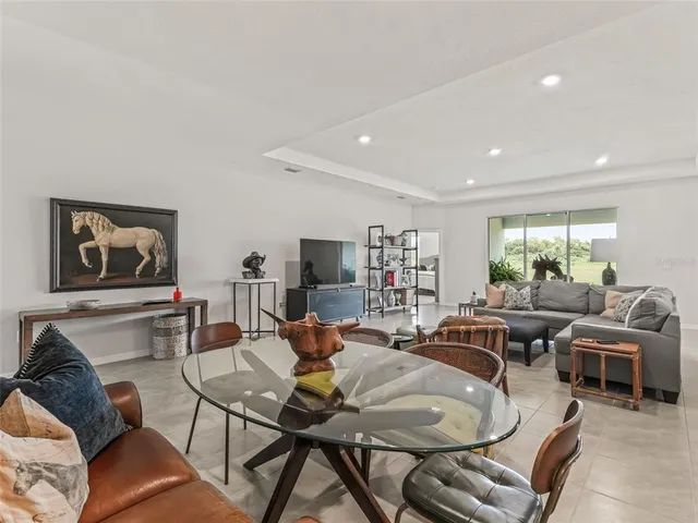 a living room with furniture kitchen view and a window