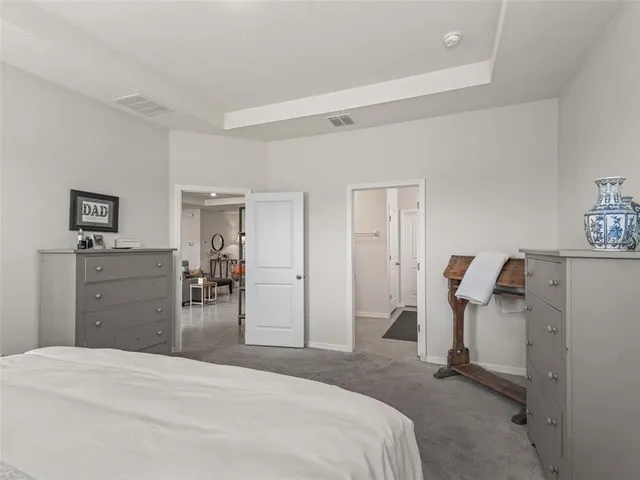 a bedroom with a bed and a view of living room