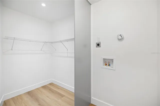 an empty room with wooden floor ceiling fan and windows