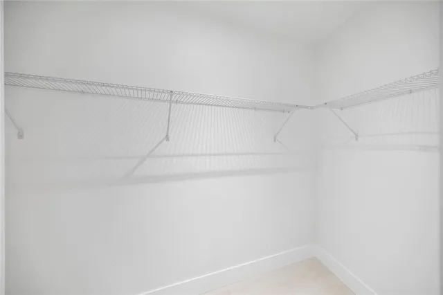 an empty room with wooden floor ceiling fan and windows