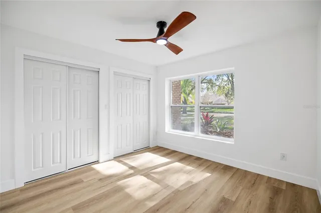 a view of a room with a ceiling fan and a window