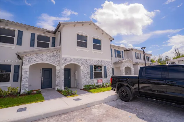 a front view of a house with a garden and parking space
