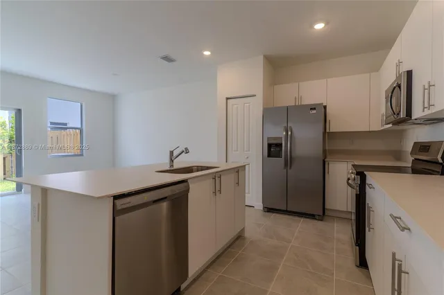 a kitchen with stainless steel appliances granite countertop a sink and refrigerator