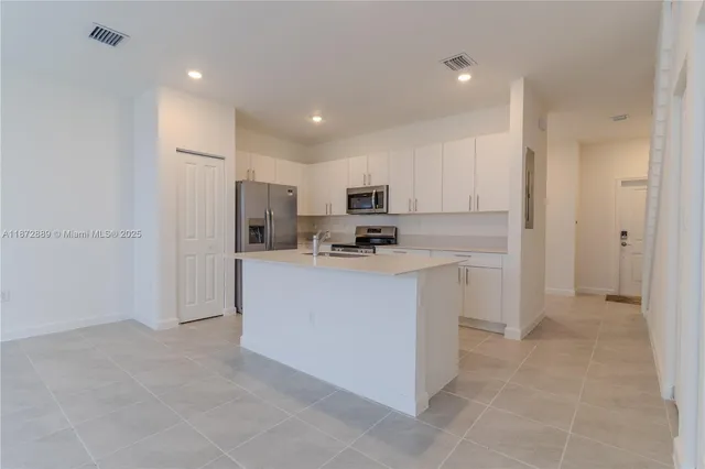 a kitchen with cabinets and refrigerator