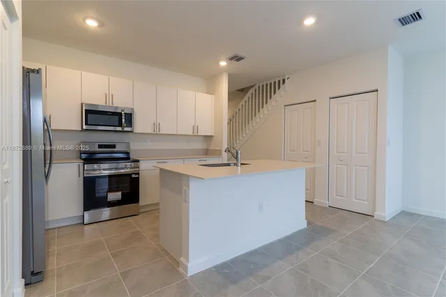 a kitchen with kitchen island and stainless steel appliances