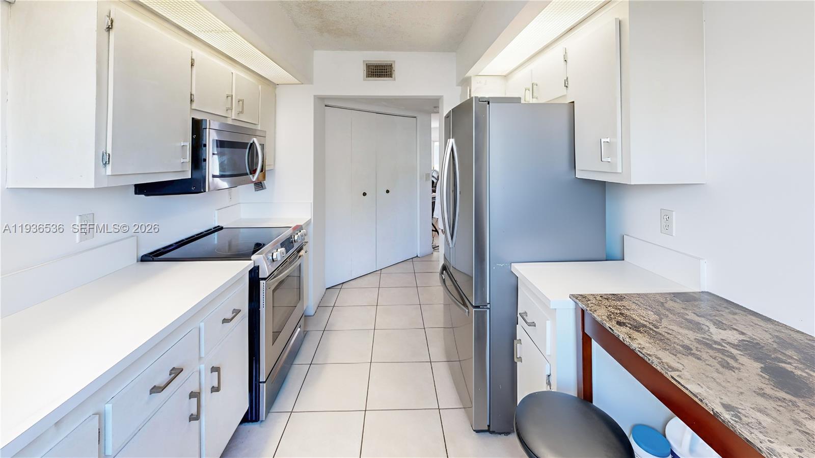 2657 Southeast 19th Court, Unit 103E Homestead, FL 33035 - Photo 13 of 50 a kitchen with stainless steel appliances granite countertop a sink stove and refrigerator