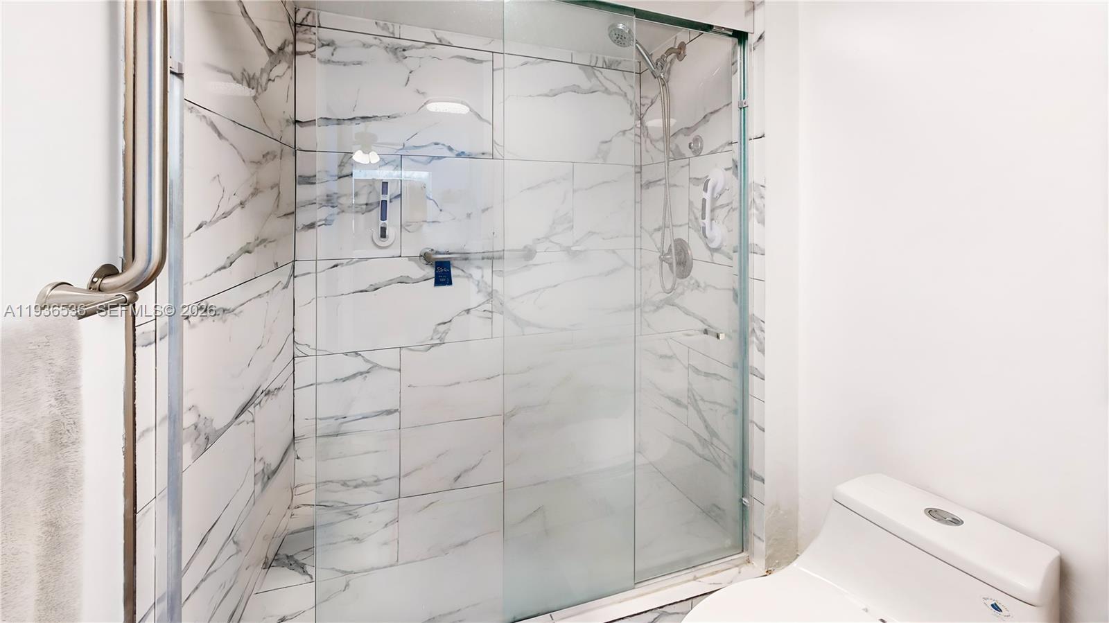 2657 Southeast 19th Court, Unit 103E Homestead, FL 33035 - Photo 19 of 50 a bathroom with a shower and toilet