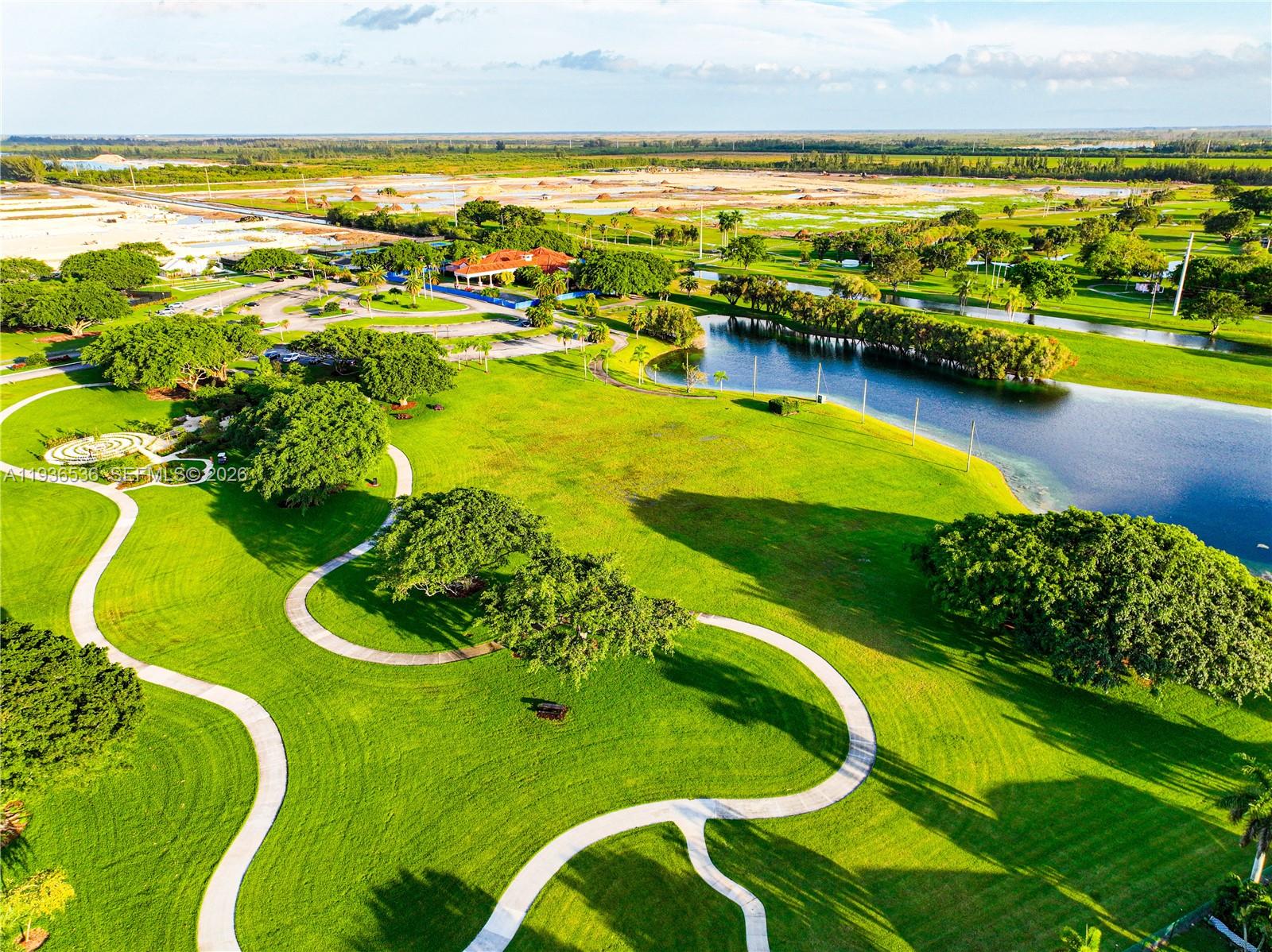 2657 Southeast 19th Court, Unit 103E Homestead, FL 33035 - Photo 43 of 50 a view of a swimming pool with an ocean and trees in the background