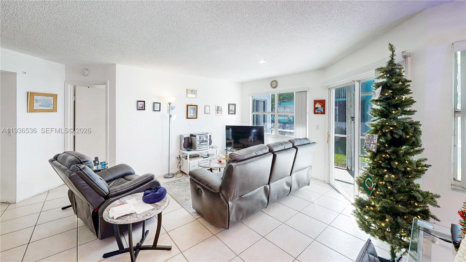 2657 Southeast 19th Court, Unit 103E Homestead, FL 33035 - Photo 9 of 50 a living room with furniture a potted plant and a fireplace
