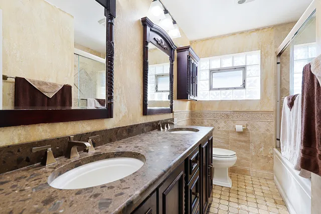a bathroom with a granite countertop sink a mirror a and a window