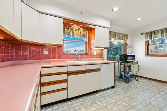 a kitchen with stainless steel appliances cabinets and a large window