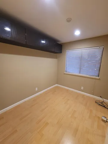 an empty room with a ceiling fan and window