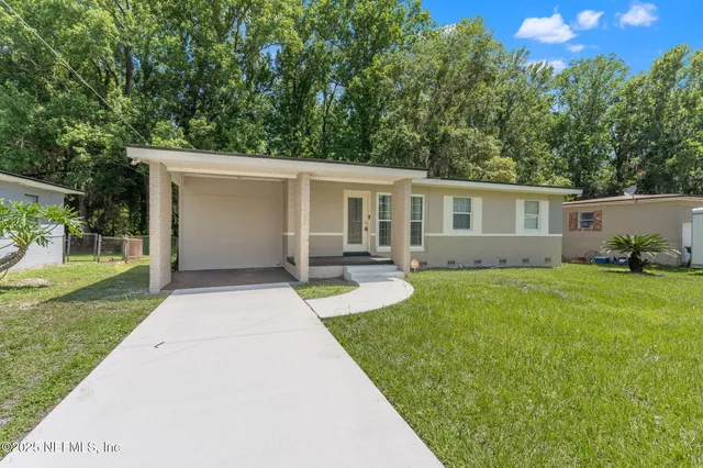 a view of backyard of house with green space