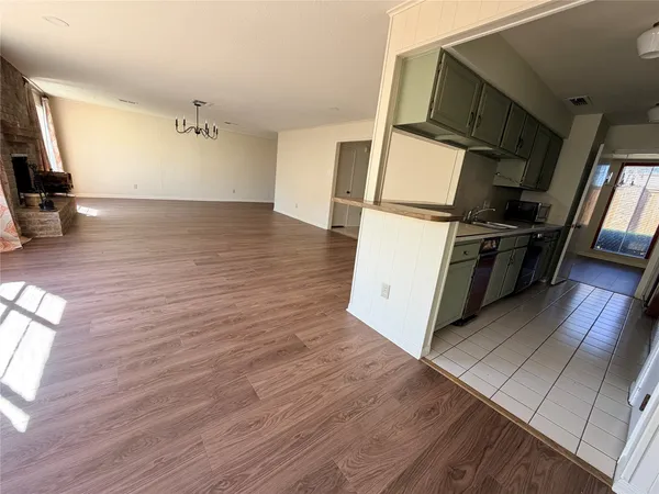 a view of a kitchen with wooden floor and electronic appliances