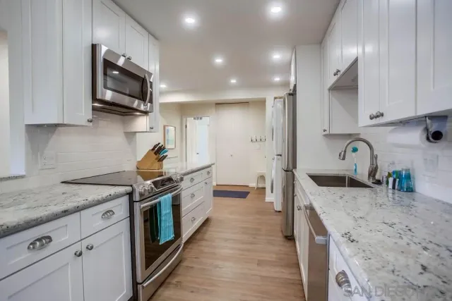 a kitchen with stainless steel appliances granite countertop a sink stove and refrigerator