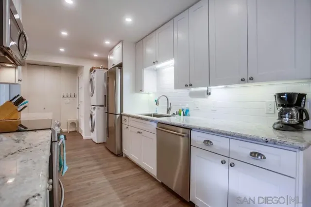 a kitchen with granite countertop cabinets stainless steel appliances and a counter space