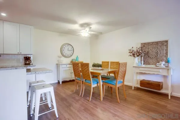 a living room with furniture a dining table wooden floor and a clock