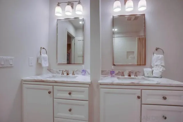 a bathroom with double sink and a mirror