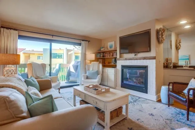 a living room with furniture a flat screen tv and a fireplace