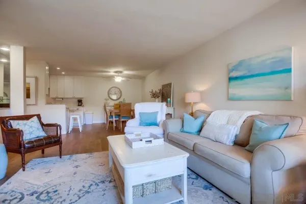 a living room with furniture and kitchen view