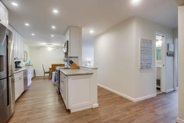 a kitchen that has a lot of cabinets and wooden floor