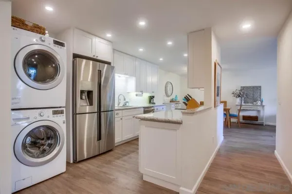 a view of a kitchen with a sink a washer and dryer