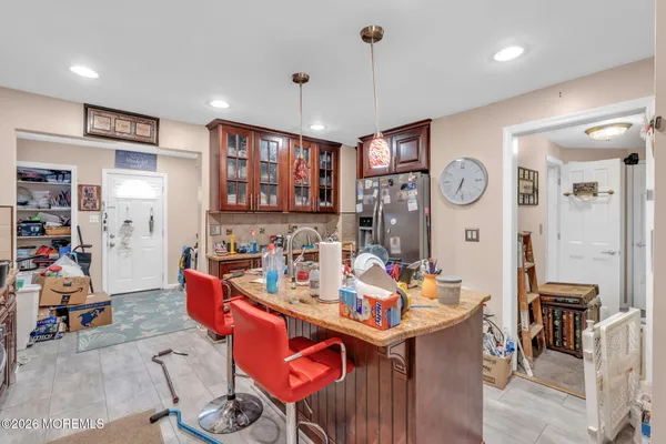 a very nice looking dining room with kitchen island stainless steel appliances a table and chairs