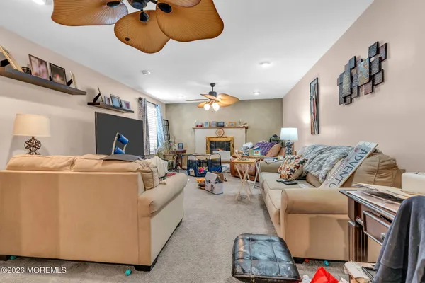 a living room with furniture and a ceiling fan