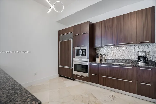 a kitchen with granite countertop a sink stove and cabinets
