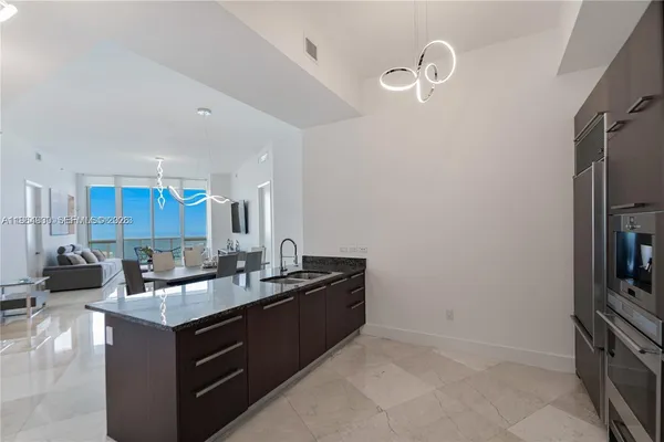 a kitchen with granite countertop stainless steel appliances and refrigerator