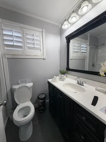 a bathroom with a toilet sink and mirror