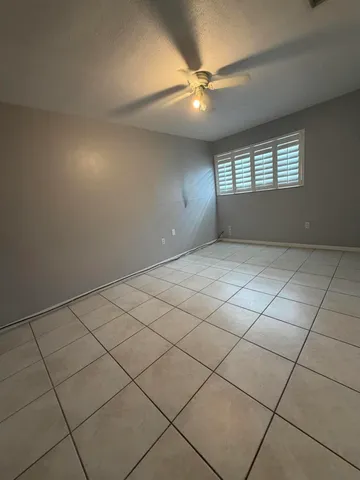 an empty room with windows and fan