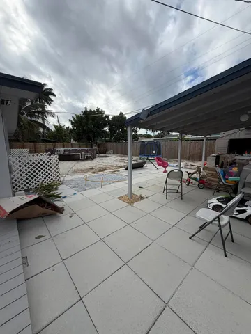 a view of backyard with swimming pool and furniture