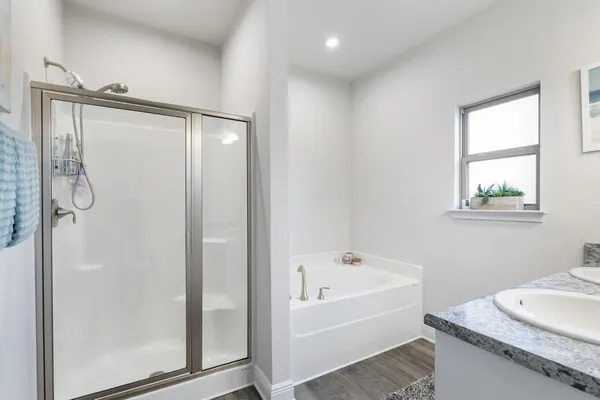 a white bath tub sitting next to a white sink and a mirror
