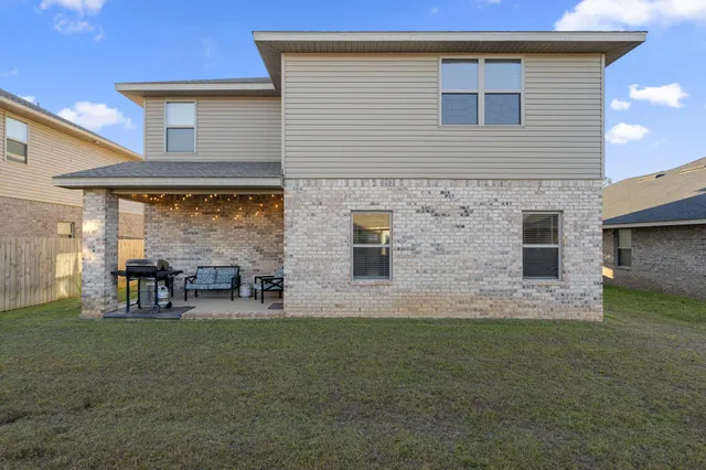 a view of a house with backyard and sitting area