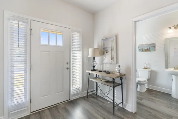 a hallway with wooden floor windows and a sink