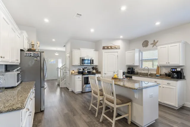 a kitchen with appliances a sink a counter top space and cabinets