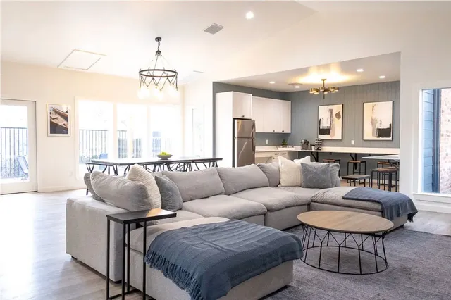 a living room with furniture a large window and a chandelier