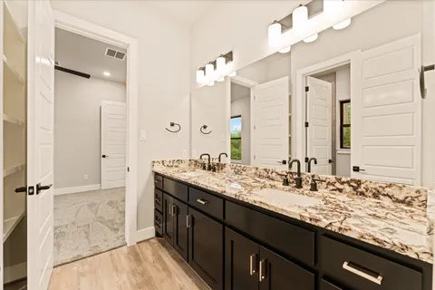 a bathroom with a granite countertop sink a large mirror and a shower