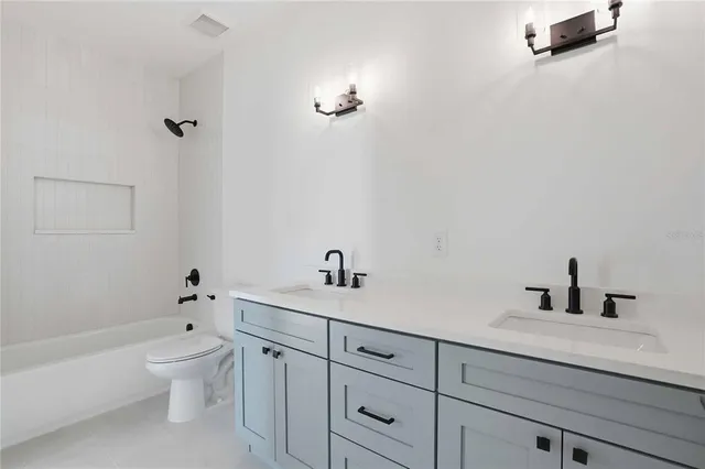 a bathroom with a granite countertop sink a toilet and a bathtub