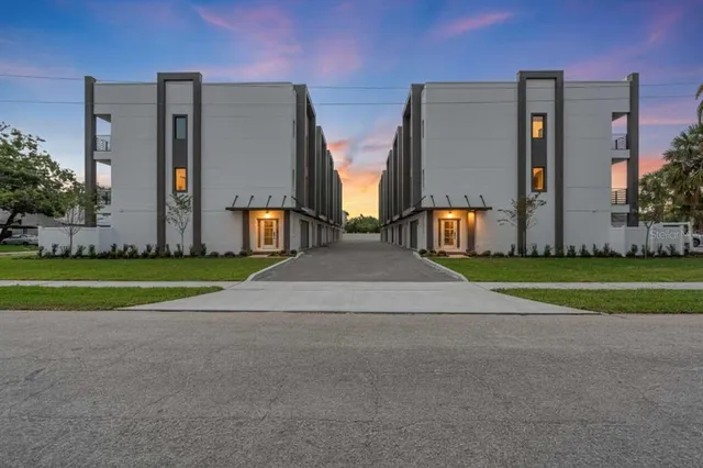 a view of a house with many windows and a big yard