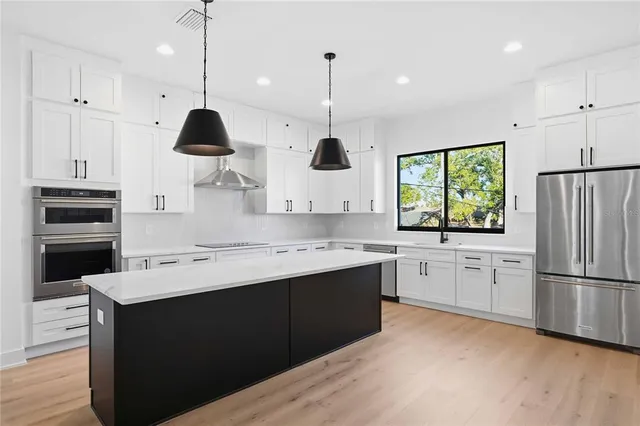 a kitchen with a sink stainless steel appliances and window