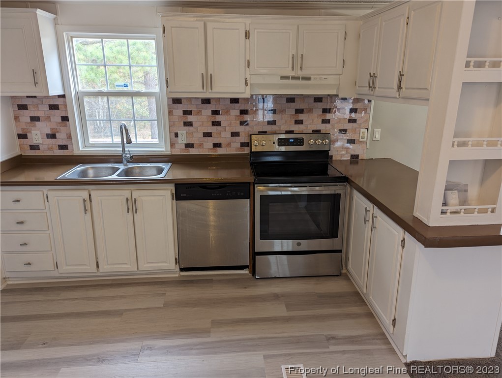 271 Eisler Drive Lillington, NC 27546 - Photo 6 of 17 a kitchen with granite countertop a stove sink and cabinets