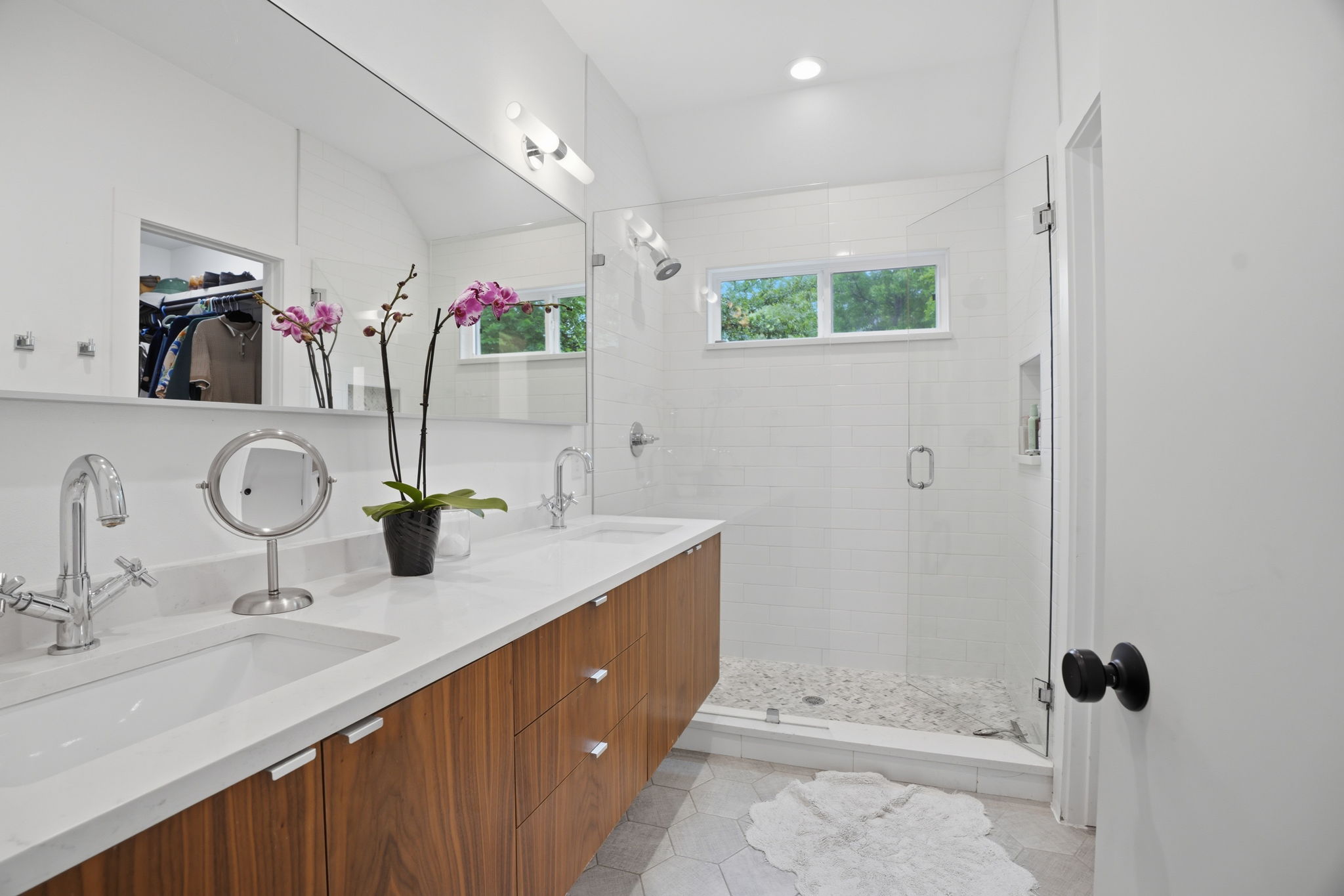 4609 Sara Drive, Unit B Austin, TX 78721 - Photo 24 of 39 A well-lit primary bathroom with dual vanities and a spacious walk-in shower.