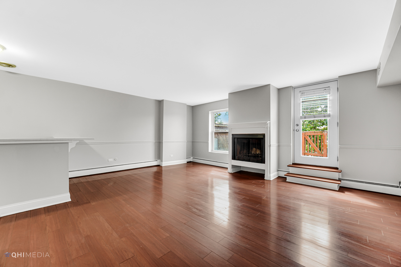 1750 North Wells Street, Unit 403 Chicago, IL 60614 - Photo 4 of 20 an empty room with wooden floor and fireplace
